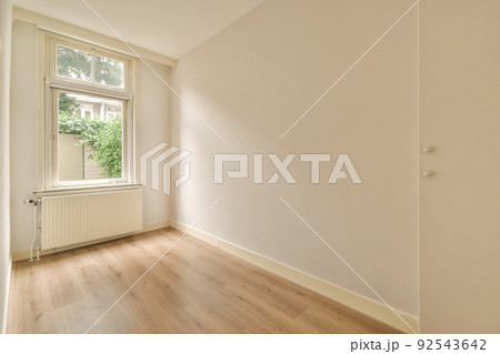 Plastic window and radiator on white wall in empty light room at home 92543642
