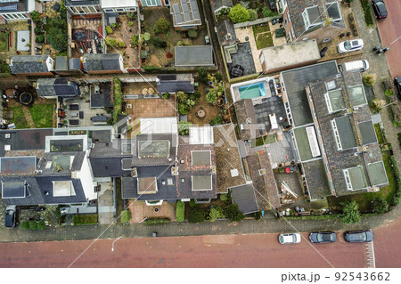 Panorama view of brick houses from an empty sidewalk street with cars, trees and lanterns 92543662
