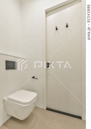 Sink base cabinet and mirror cabinet in white tiled bathroom with wall hung toilet Sink base cabinet and mirror cabinet in white tiled bathroom with wall hung toilet 92543886