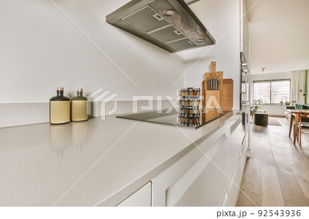 Interior of light kitchen with modern cupboards and appliances in modern flat at daytime 92543936