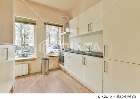Interior of empty white kitchen with windows and wooden parquet floor 92544438