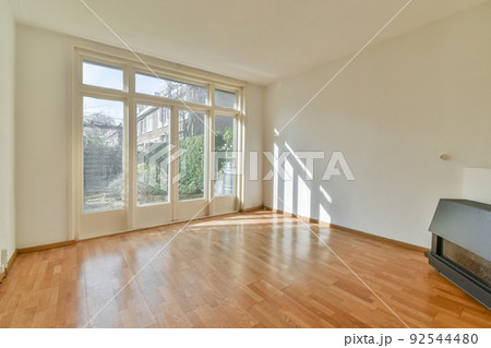 Modern counters with stools placed on wooden floor near electric fireplace in spacious room with white walls Modern counters with stools placed on wooden floor near electric fireplace in spacious room with white walls 92544480