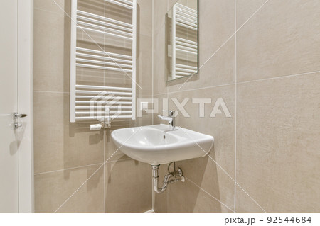 Sink with tap and liquid soap hanging on tiled wall under mirror in contemporary restroom at home Sink with tap and liquid soap hanging on tiled wall under mirror in contemporary restroom at home 92544684