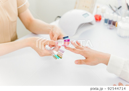ネイルサロンでカラーを選ぶ女性の手元 92544714