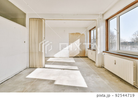 Plastic window and radiator on white wall in empty light room at home 92544719