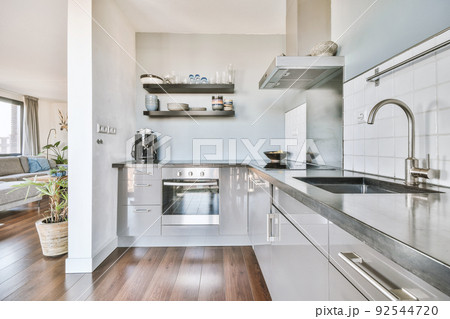 Corner cupboards and table with chairs located in light kitchen of contemporary flat Corner cupboards and table with chairs located in light kitchen of contemporary flat 92544720