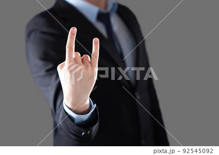 A man's hand giving the Rock and Roll sign. A man in a suit and tie in a blur. A man's hand giving the Rock and Roll sign. A man in a suit and tie in a blur. 92545092