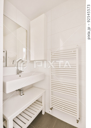 Sink with tap and liquid soap hanging on tiled wall under mirror in contemporary restroom at home Sink with tap and liquid soap hanging on tiled wall under mirror in contemporary restroom at home 92545573