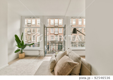 Shabby wooden table with chairs and vase located near comfortable couch against light walls with decorations and TV in modern apartment Shabby wooden table with chairs and vase located near comfortable couch against light walls with decorations and TV in modern apartment 92546536