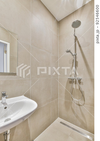 Sinks with mirrors and shower box with glass door in modern bathroom with white tiled walls 92546600