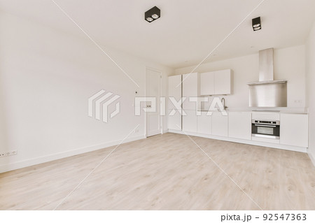 Interior of empty white kitchen with windows and wooden parquet floor Interior of empty white kitchen with windows and wooden parquet floor 92547363