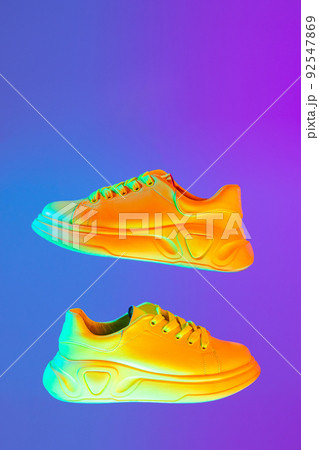 Image of fashionable sports shoes, sneakers isolated over colored neon background. Urban city fashion, fitness, sport, training concept. 92547869