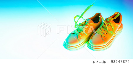 Modern sports shoes over neoned background. Sneakers or trainers isolated. Athletic shoes. fitness, sport, training concept. Urban fashion 92547874