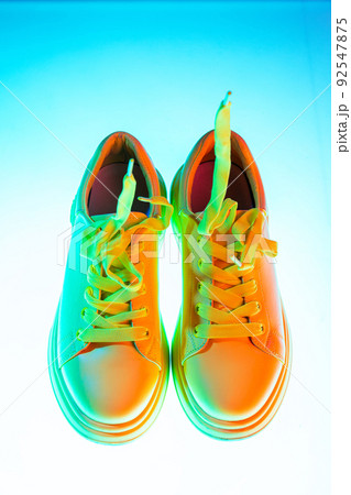 Aerial view of sports shoes, sneakers isolated over neoned background. Urban city fashion, fitness, sport, training concept. 92547875