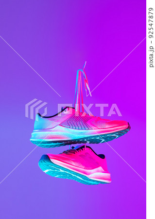 Image of fashionable sports shoes, sneakers isolated over colored neon background. Urban city fashion, fitness, sport, training concept. 92547879
