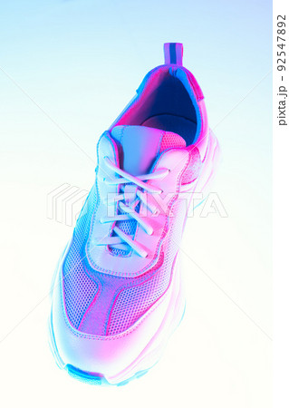 One sports shoe isolated over neoned background. Urban city fashion, fitness, sport, training concept. 92547892
