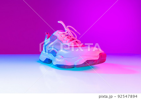 One sports shoe isolated over neoned background. Urban city fashion, fitness, sport, training concept. 92547894