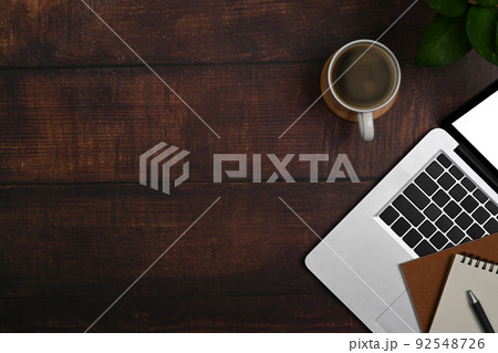 Laptop computer, coffee cup, notebook and houseplant on wooden table. Top view with copy space Laptop computer, coffee cup, notebook and houseplant on wooden table. Top view with copy space 92548726