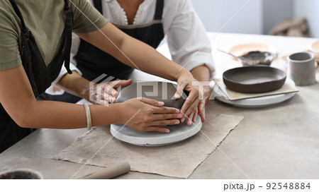 Young asian woman and mature woman molding clay, enjoy making handcrafted ceramics in pottery workshop 92548884