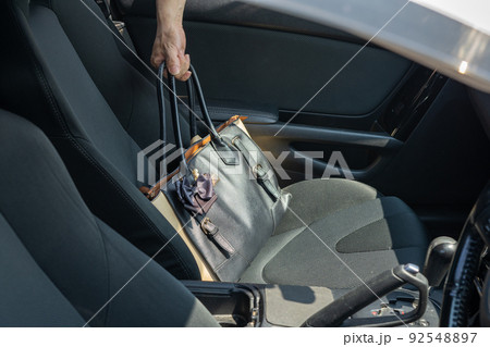 車の助手席からバッグを抜き取る手 車の助手席からバッグを抜き取る手 92548897