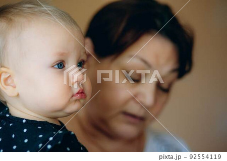 little caucasian baby girl and grandmother. woman hugging granddaugher little caucasian baby girl and grandmother. woman hugging granddaugher 92554119