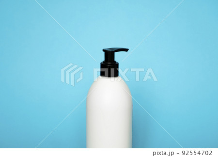 White plastic soap dispenser pump bottle isolated on blue background. Skin care lotion. Bathing essential product. Shampoo bottle. Bath and body lotion. Fine liquid hand wash. Bathroom accessories. 92554702