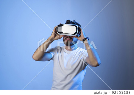 Closeup portrait of a man wearing VR goggles, working over virtual project, enjoying new reality, playing video game. Technology, innovation gadgets. 92555183