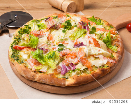 pizza with salmon, tomatoes, salad mix and green butter 92555268