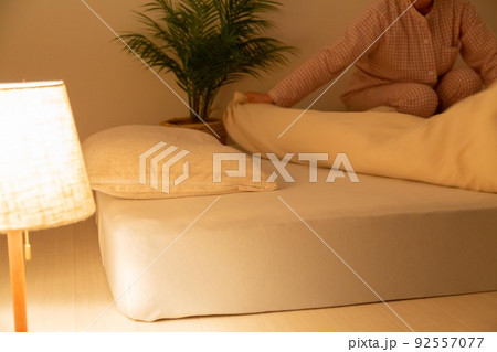 パジャマを着て布団を整えるミドル女性 パジャマを着て布団を整えるミドル女性 92557077