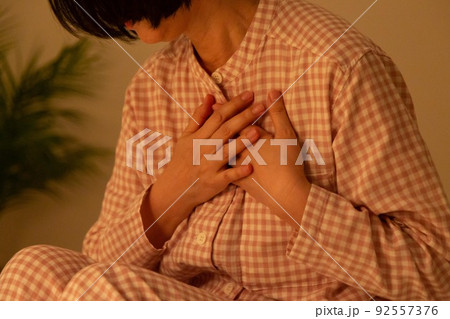 パジャマ姿で胸痛に苦しむミドル女性 92557376