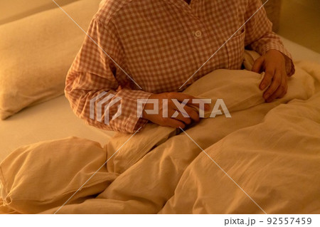 パジャマを着て布団に座るミドル女性 パジャマを着て布団に座るミドル女性 92557459