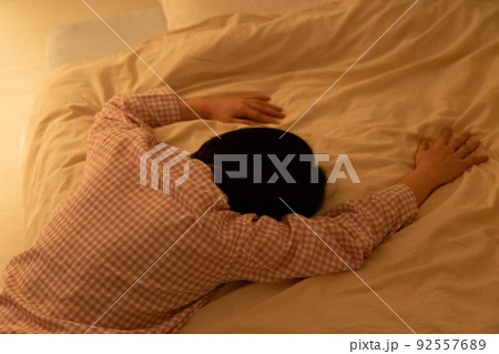 パジャマを着て布団に倒れこむミドル女性 92557689