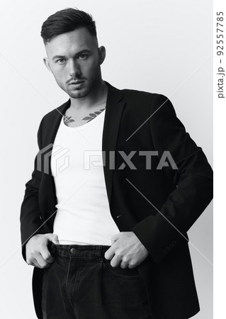 Modelling snapshots. Self-confident narcissistic attractive handsome man in classic suit hold hands on belt posing isolated in white studio background. Black White concept. Fashion offer. Copy space 92557785