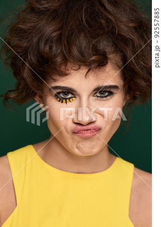 young curly woman with creative make-up in yellow dress 92557885