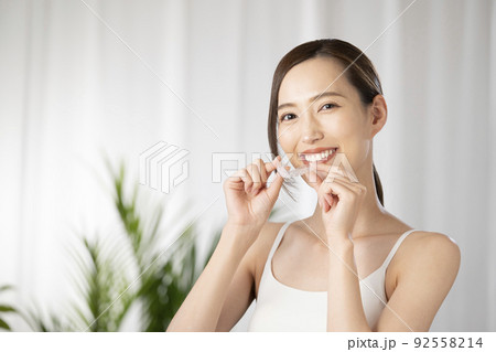 両手でマウスピースを持つ女性 92558214