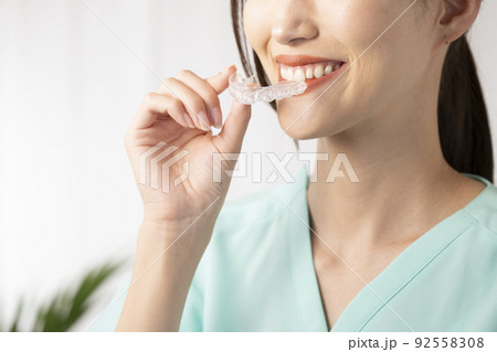 片手でマウスピースを持つ女性 92558308