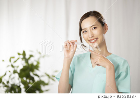 片手でマウスピースを持つ女性 片手でマウスピースを持つ女性 92558337