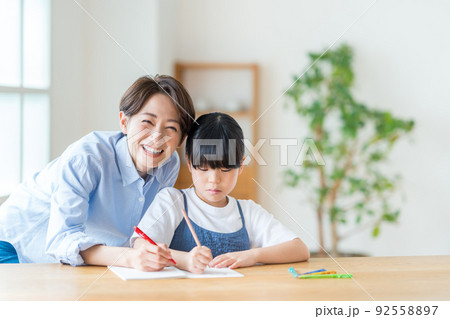 リビングで一緒に宿題をする親子(母子) リビングで一緒に宿題をする親子(母子) 92558897