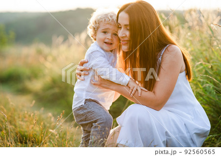 Mother hugs her curly son in nature 92560565