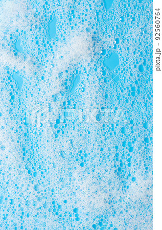 Texture of white foam on a blue background. Cleansing mousse for the face or bath foam or washing powder. Closeup Texture of white foam on a blue background. Cleansing mousse for the face or bath foam or washing powder. Closeup 92560764