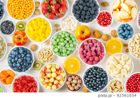 Berries, fruits and nuts on a white wooden background. Vegetarian food. 92561034