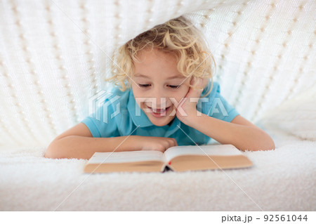 Child reading book in bed. Kids read books. Child reading book in bed. Kids read books. 92561044