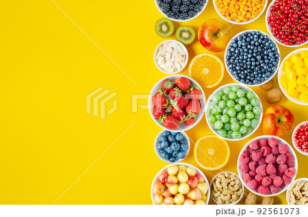 Berries, fruits and nuts on a yellow background. Vegetarian food. Copy space Berries, fruits and nuts on a yellow background. Vegetarian food. Copy space 92561073