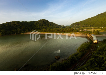 朝焼けの宮崎県日南市山王浜の波打ち際の隈谷川橋梁を走る日南線キハ40 朝焼けの宮崎県日南市山王浜の波打ち際の隈谷川橋梁を走る日南線キハ40 92561337