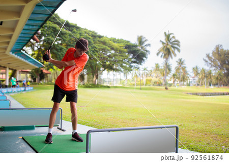 Young man hitting ball on golf driving range. 92561874