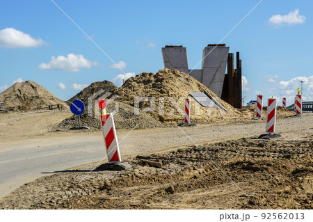 Road overpass concrete bridge construction site view with concrete support and traffic warning signs 92562013
