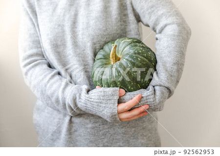 Autumnal Background. Unrecognizable woman hand holding in hands autumn fall pumpkin isolated on white background. Change of seasons ripe organic food, Halloween party Thanksgiving day 92562953