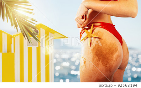 Woman with red swimsuit and starfish in hand ready for the summer 92563194