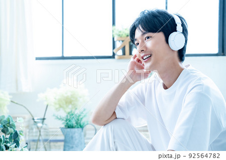ヘッドフォンで音楽を聴く若い男性 92564782