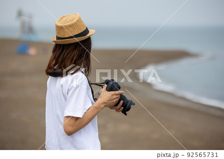 海辺の風景を撮影する女性 92565731